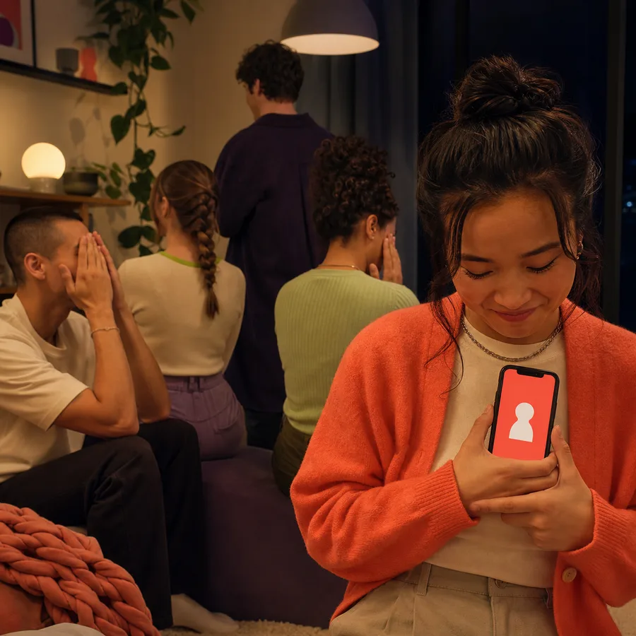 A player checks a private role while the rest of the group looks away